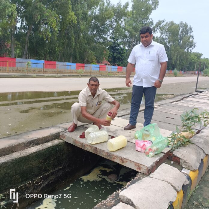 नाले में बहाते अधिकारी