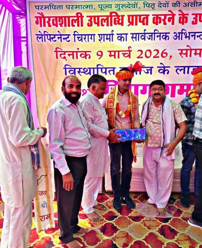 चिराग शर्मा का साफा बांधकर और माल्यार्पण कर अभिनंदन करते ग्रामीण व अतिथि