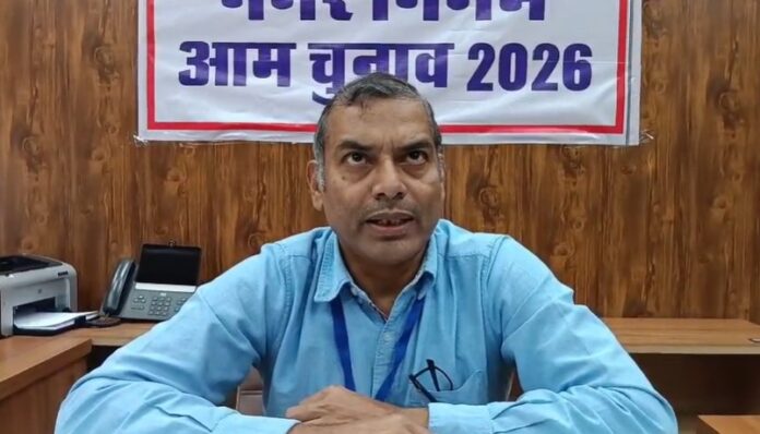 नामांकन पत्रों की जांच करते रिटर्निंग अधिकारी